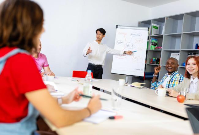 Meeting in a company. The colleagues are discussing something written on the flipchart.