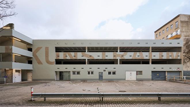 The photo shows the Kunstraum Potsdamer Straße and the car park in front of the building.